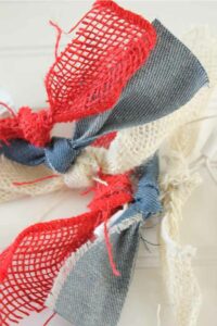 DIY slinger met lampjes en reepjes denim en jute usa themafeest decoreren