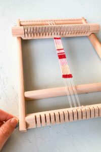 hoe weef je een armband - haal het weefproject van het weefraam en maak een vlecht