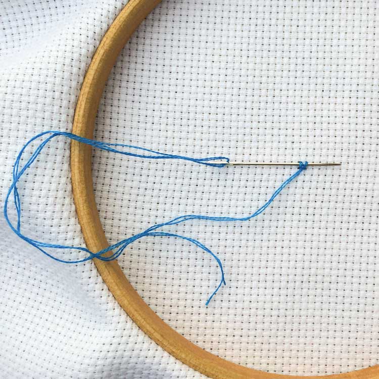 Bring your needle to the backside of your work and thread the needle underneath the horizontal loop and the vertical stitch 3